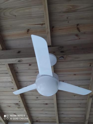 un ventilador de techo blanco en el techo de madera en Hospedaria Central - Hostel, en Bombinhas