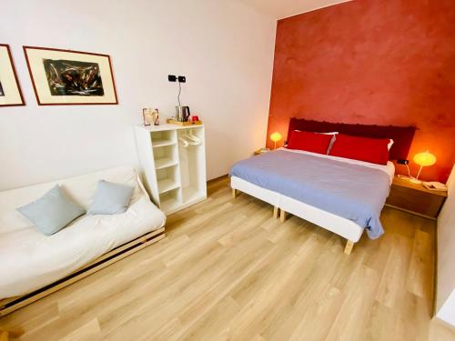 a bedroom with two beds and a red wall at Notte di Note - home hospitality in Busto Arsizio