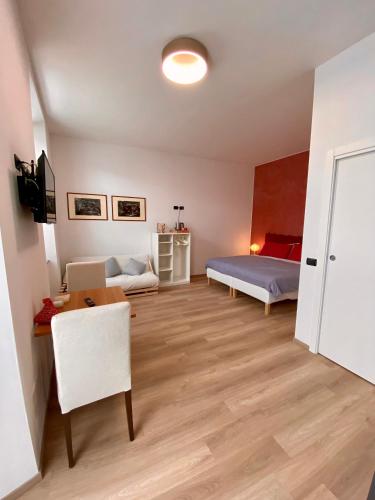 a room with two beds and a desk and a table at Notte di Note - home hospitality in Busto Arsizio