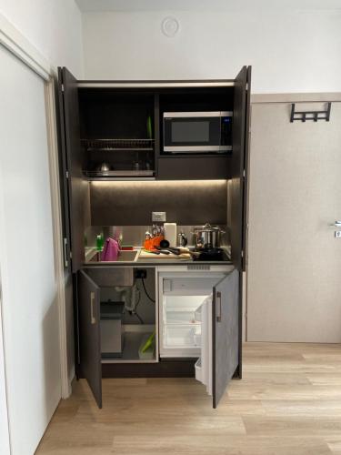 a small kitchen with a sink and a microwave at Notte di Note - home hospitality in Busto Arsizio
