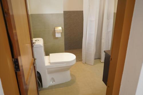 ein Badezimmer mit einem weißen WC und einem Waschbecken in der Unterkunft Oriole Homestay in Thekkady
