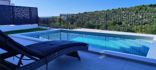 una piscina con una silla junto a una silla en Apartman Retro with gym en Murter