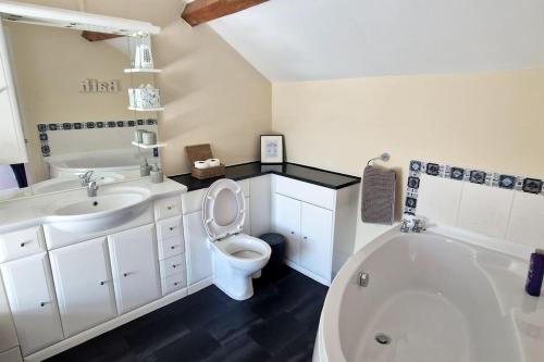 a bathroom with a tub and a toilet and a sink at Two bedroom character cottage in Rhuddlan
