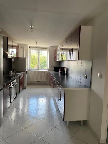 une grande cuisine avec un comptoir et une fenêtre dans l'établissement IRIS 82, à Lorette