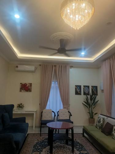 a living room with a couch and a ceiling fan at Cp homestay in Batu Kurau