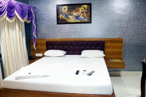 a bedroom with a bed with two shoes on it at White Sand Resort Manori Mumbai Malad West in Mumbai