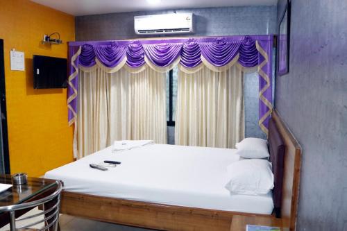 a bedroom with a bed with a purple canopy at White Sand Resort Manori Mumbai Malad West in Mumbai