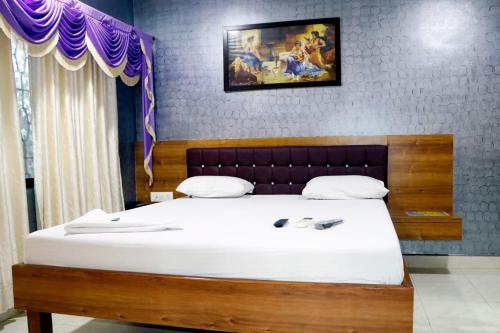 a bedroom with a large bed with white sheets at White Sand Resort Manori Mumbai Malad West in Mumbai