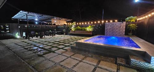 a backyard with a swimming pool at night at Jorge's Black Cabin in Manolo Fortich