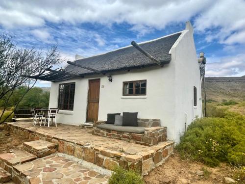 een wit huis met een patio ervoor bij Enjo Nature Farm in Cederberg