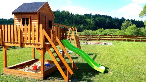 a playground with a slide and a play house at Domki OstoYa Bieszczady/Solina in Myczkowce