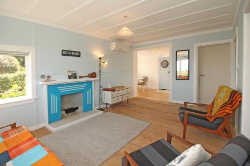 a living room with a couch and a fireplace at Classic bach near the beach in Oneroa
