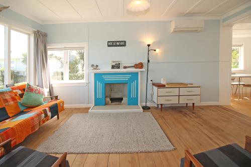 a living room with a blue fire place at Classic bach near the beach in Oneroa