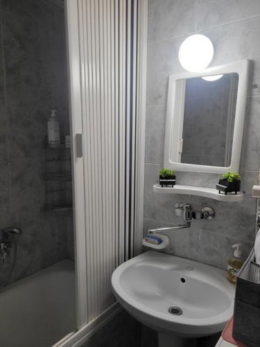 een badkamer met een wastafel, een toilet en een spiegel bij Nika's Apartment in Skopje