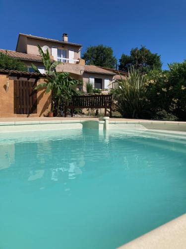 a large swimming pool in front of a house at Villa Câline chambres d'hôtes in Vesseaux