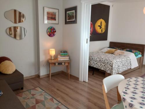 um pequeno quarto com uma cama e uma mesa em Klimatyczne mieszkanie w Nowym Porcie em Gdańsk