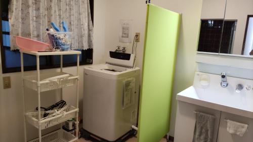 a kitchen with a green refrigerator and a washing machine at シェアハウスの和室7畳or洋室 24時間スーパー徒歩5分 共同ワークスペース有 in Kitagata