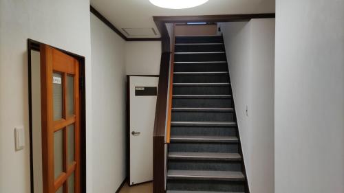 a staircase leading up to a room with a door at シェアハウスの和室7畳or洋室 24時間スーパー徒歩5分 共同ワークスペース有 in Kitagata