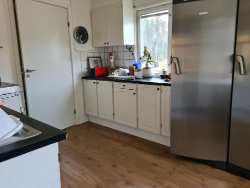 uma cozinha com armários brancos e um frigorífico de aço inoxidável em Mattmar vila 