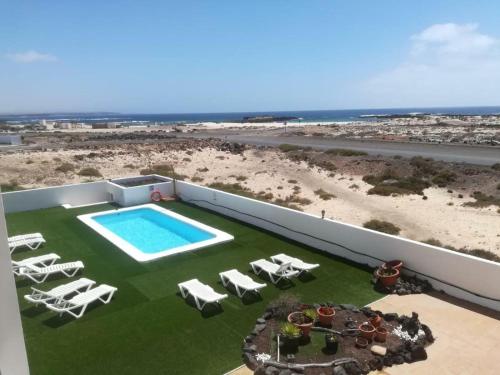 an aerial view of a resort with a swimming pool and chairs at El Cotillo On The Beach Playa La Concha Sea view in Cotillo