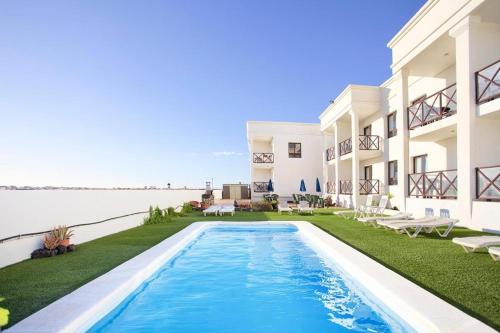 a house with a swimming pool next to the water at El Cotillo On The Beach Playa La Concha Sea view in Cotillo
