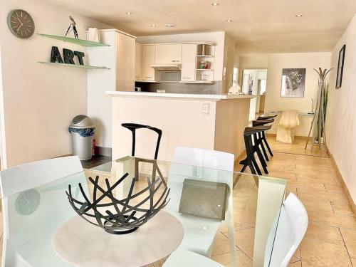 une salle à manger et une cuisine avec une table et des chaises en verre dans l'établissement Appartement Cannes 3 chambres - 8B2, à Cannes