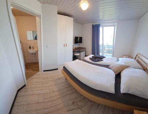een slaapkamer met een groot bed en een groot raam bij MBar in Altnau
