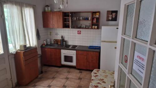 a small kitchen with wooden cabinets and a white refrigerator at Flava Hostel in Cluj-Napoca