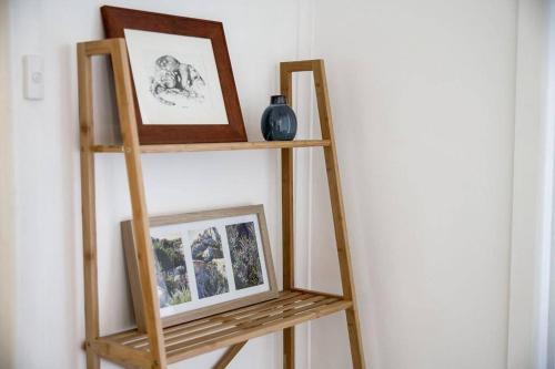a wooden shelf with two pictures on a wall at Killora Coastal Shack in Killora