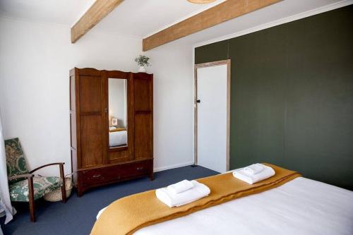 a bedroom with a bed with two towels on it at Killora Coastal Shack in Killora