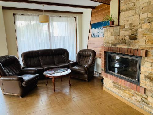 a living room with leather furniture and a fireplace at Forest fairy tale in Bansko