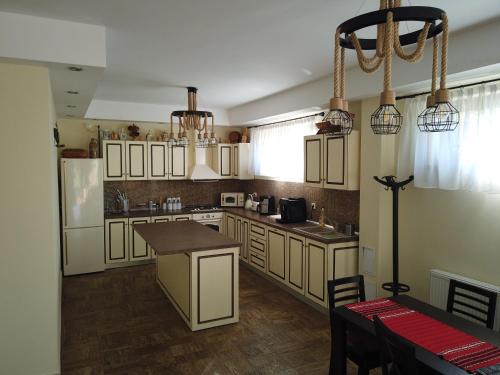 a kitchen with white cabinets and a table in it at Transylvanian Views in Peştera