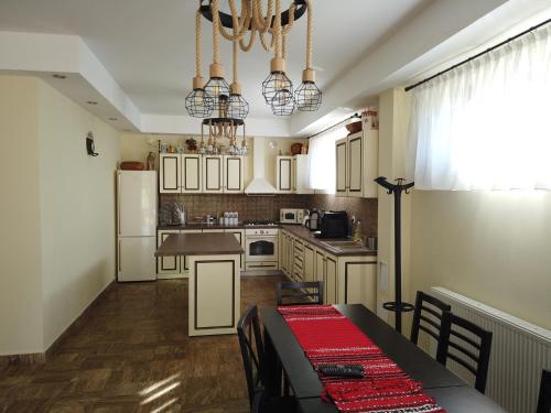 a kitchen with a table and a kitchen with white appliances at Transylvanian Views in Peştera