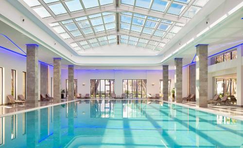 a large swimming pool in a building with a ceiling at Pinegrove Apartment in Durrës