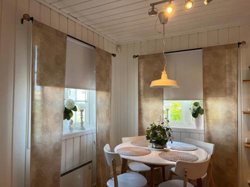 een eetkamer met een tafel en stoelen bij Lilla gröna huset på gården in Härnösand