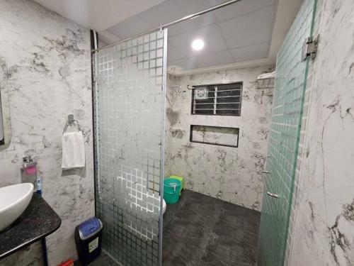 a bathroom with a shower with a sink and a toilet at SS Lumina Villa in Bengaluru