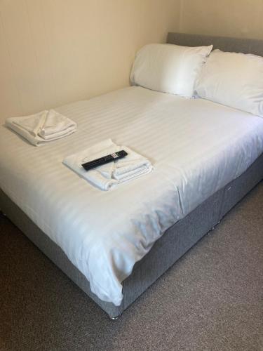 a bed with white sheets and a book on it at Town House 8-8A High Street in Newport