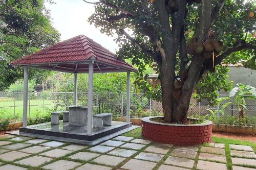 a picnic shelter next to a tree in a park at SS Lumina Villa in Bengaluru