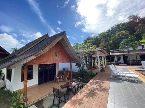 a house with a deck with chairs and tables at Sunrise House in Ko Yao Noi