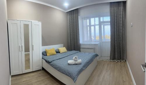 een kleine slaapkamer met een bed en een raam bij park home uralsk in Oral