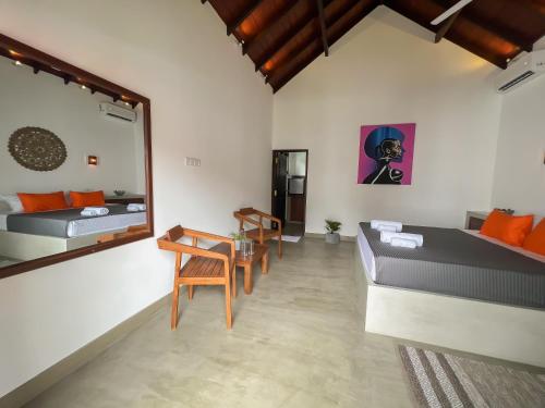 a room with two beds and a table and a mirror at Lum Residence in Ahangama