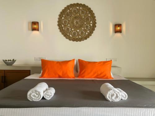 a bedroom with orange and white towels on a bed at Lum Residence in Ahangama