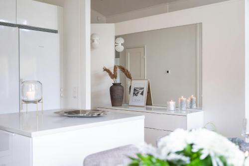 a white kitchen with a mirror and a table at Villa Nordic Rovaniemi in Rovaniemi