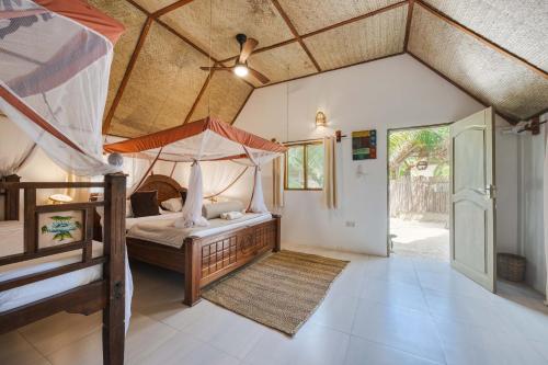 a bedroom with a canopy bed and a doorway at Cinnamon Hotel in Jambiani