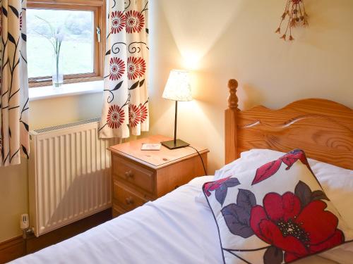 a bedroom with a bed and a lamp and a window at The Stable - Uk10271 in Appersett