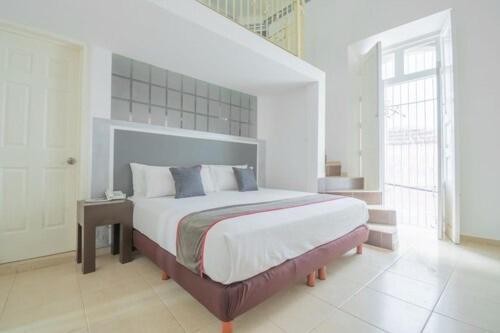 1 dormitorio con 1 cama grande en una habitación blanca en Mansión Aréchiga en Zacatecas