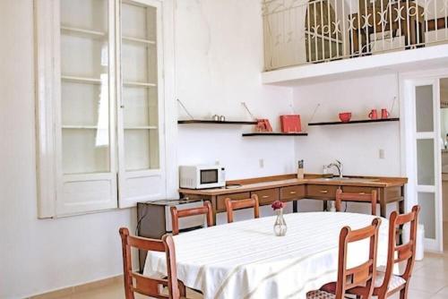 uma cozinha com uma mesa e cadeiras brancas e um balcão em Mansión Aréchiga em Zacatecas
