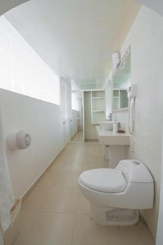 Baño blanco con aseo y 2 lavabos en Mansión Aréchiga en Zacatecas
