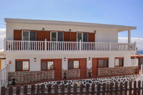 a white house with red doors and a balcony at Mary (A): Confort y playa. in Breña Baja