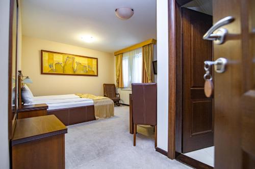 a hotel room with a bedroom with a bed and a door at Vila Pina in Zlatibor